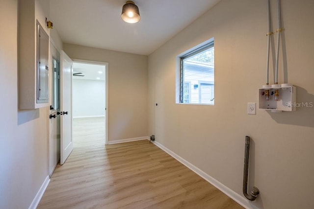 laundry room with light wood-style flooring and baseboards