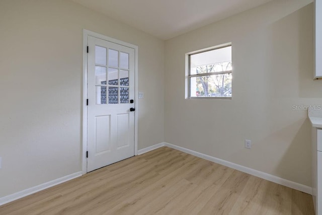 entryway with light wood finished floors and baseboards