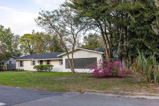 single story home with a front yard and fence