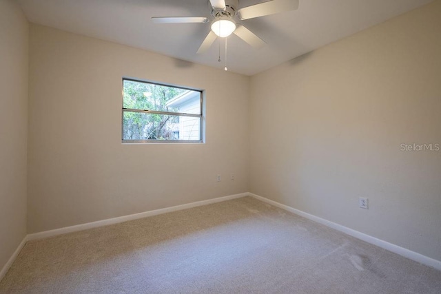 empty room with carpet floors, baseboards, and a ceiling fan