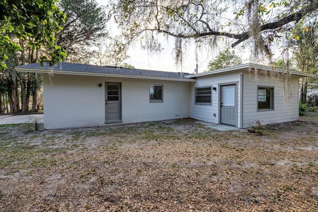 rear view of house featuring brick siding