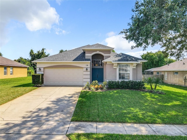 view of front of property featuring a front lawn, concrete driveway, an attached garage, and stucco siding