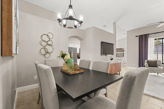 dining area featuring light tile patterned floors, baseboards, arched walkways, and a notable chandelier