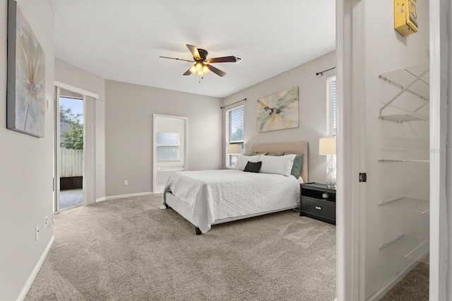 carpeted bedroom with access to outside, ceiling fan, and baseboards