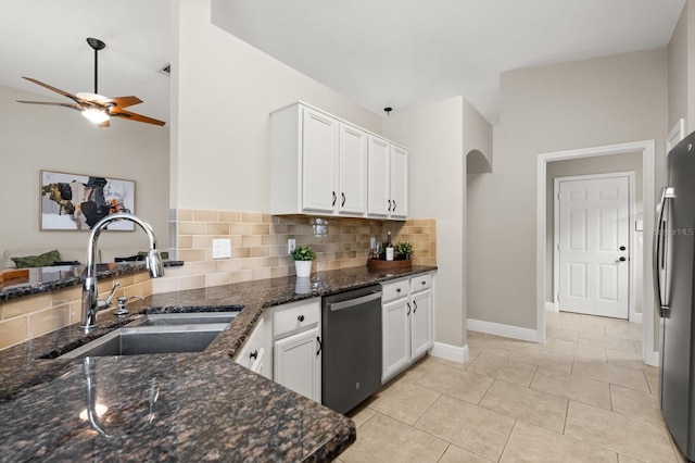 kitchen with arched walkways, a sink, white cabinetry, vaulted ceiling, and appliances with stainless steel finishes