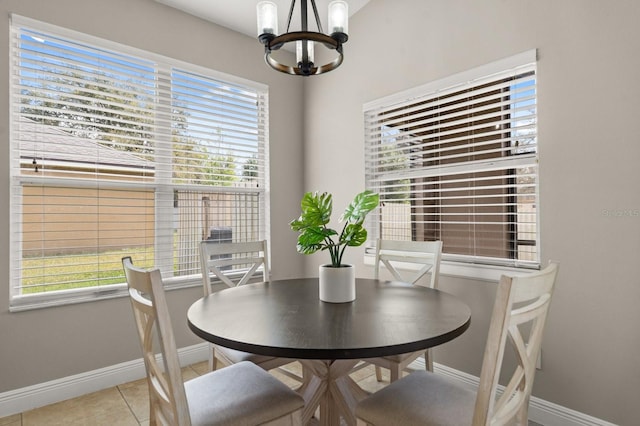 dining space with an inviting chandelier, light tile patterned floors, baseboards, and a wealth of natural light