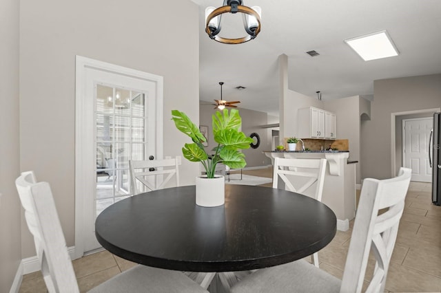 dining room with light tile patterned floors, visible vents, baseboards, and ceiling fan with notable chandelier