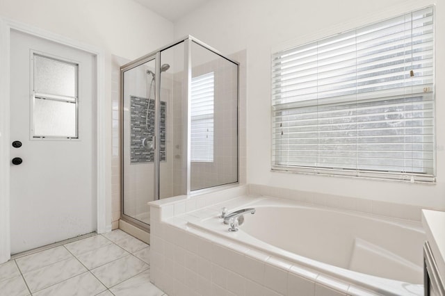 bathroom featuring a garden tub, a shower stall, and tile patterned floors