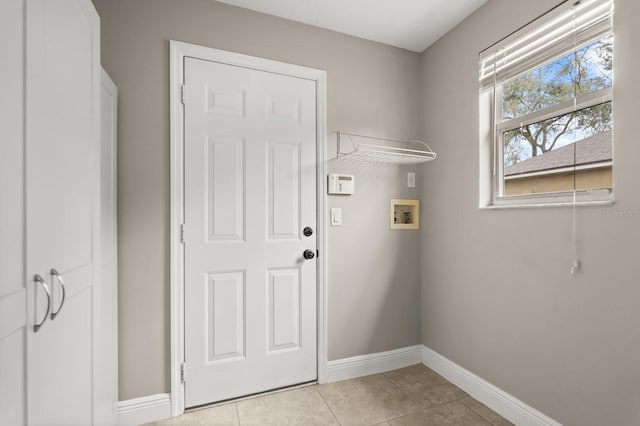 laundry room featuring washer hookup, laundry area, light tile patterned flooring, and baseboards