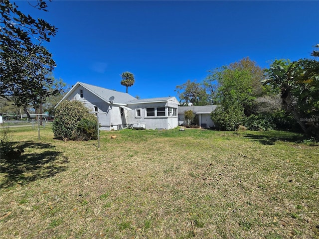 back of property featuring a yard and fence