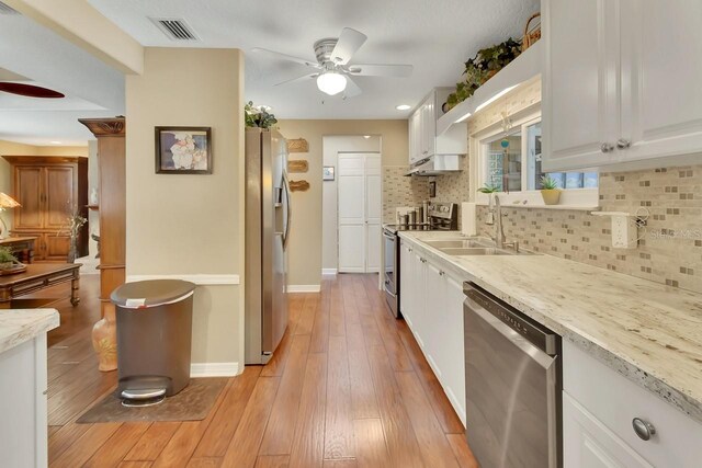 kitchen with light wood-type flooring, visible vents, appliances with stainless steel finishes, and white cabinets