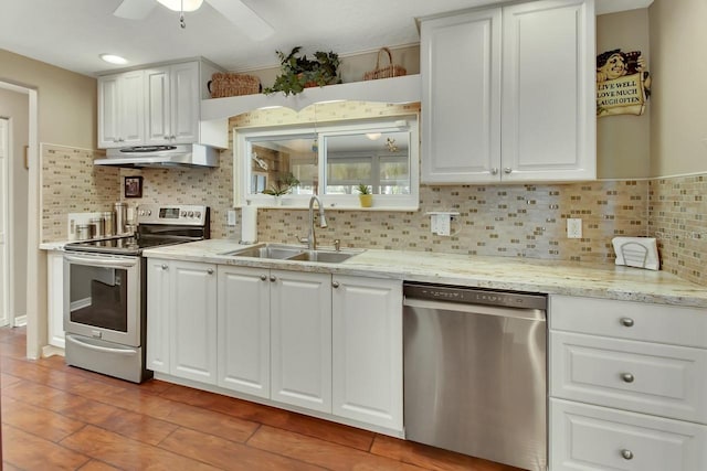 kitchen featuring white cabinets, decorative backsplash, stainless steel appliances, under cabinet range hood, and a sink