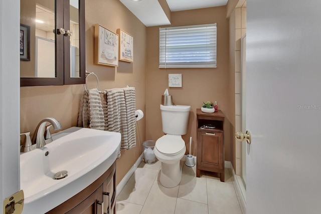 bathroom featuring baseboards, vanity, toilet, and tile patterned floors