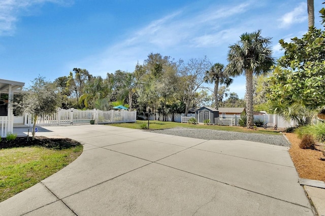 view of street featuring driveway and a gate