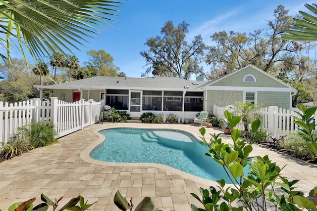 view of swimming pool featuring a sunroom, a fenced backyard, and a patio area