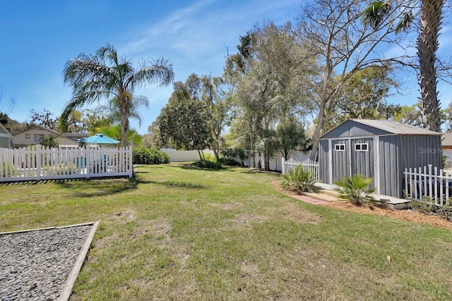 view of yard featuring an outbuilding, a fenced backyard, and a storage unit