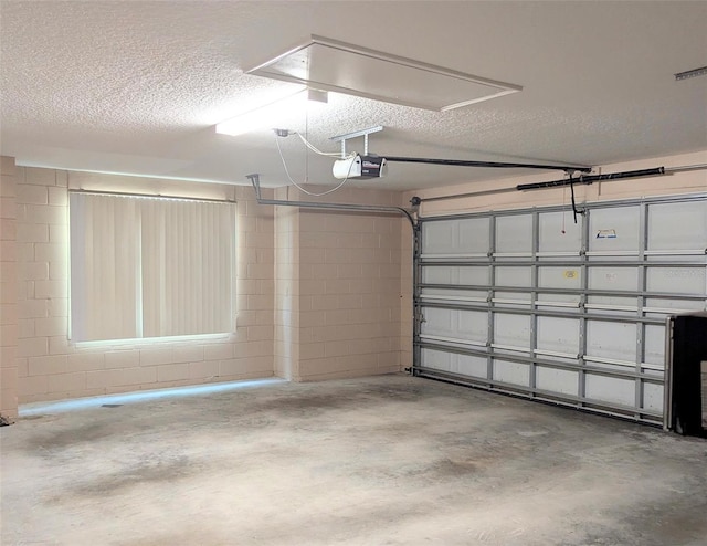 garage with concrete block wall and a garage door opener