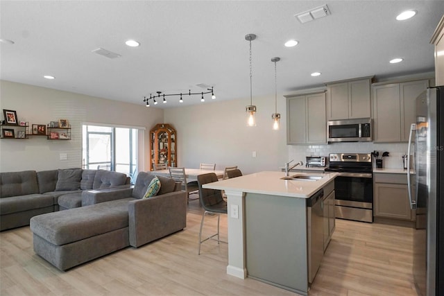 kitchen featuring appliances with stainless steel finishes, open floor plan, and gray cabinetry