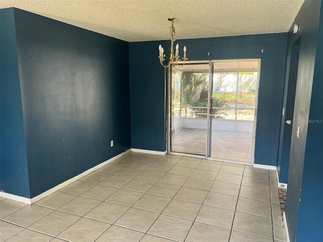 unfurnished dining area featuring a chandelier, tile patterned flooring, a textured ceiling, and baseboards