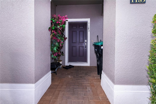 property entrance with stucco siding