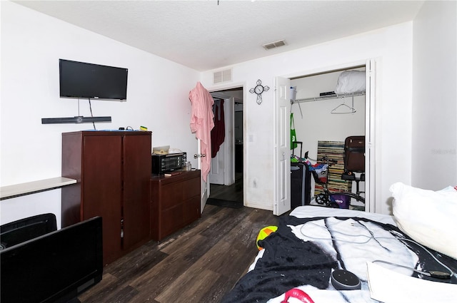 bedroom featuring a closet, visible vents, and dark wood-style flooring