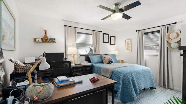 bedroom featuring ceiling fan, a textured ceiling, and wood finished floors