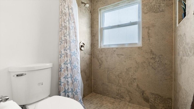 bathroom with tiled shower and toilet