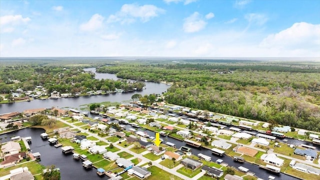 drone / aerial view featuring a water view, a wooded view, and a residential view