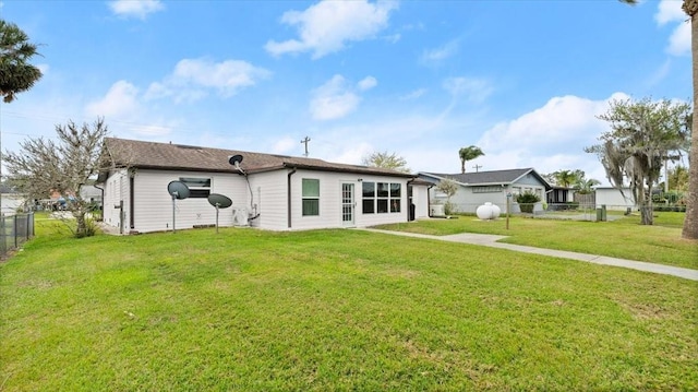 rear view of house featuring a fenced backyard and a yard