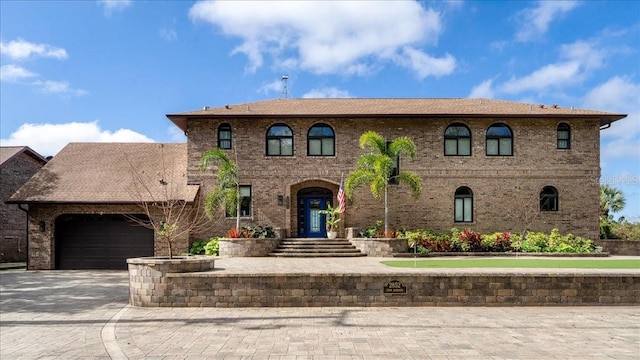 view of front facade featuring brick siding, a garage, and driveway