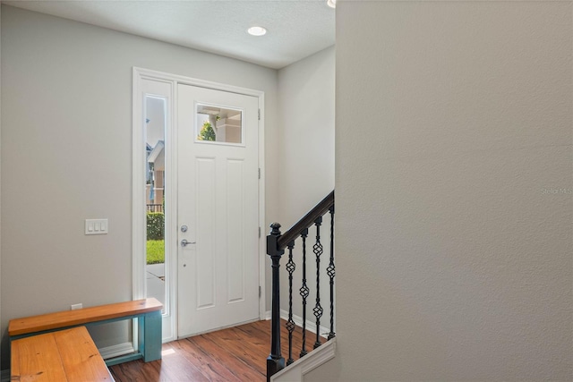 entrance foyer with stairway, wood finished floors, and a wealth of natural light