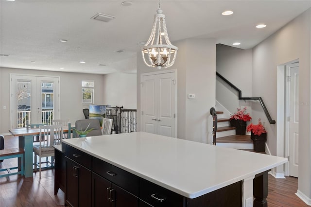 kitchen featuring dark wood-style flooring, decorative light fixtures, recessed lighting, light countertops, and visible vents