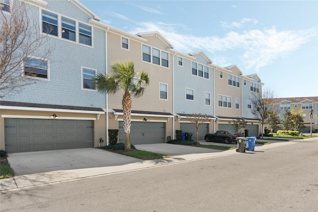 view of building exterior featuring a residential view, driveway, and an attached garage