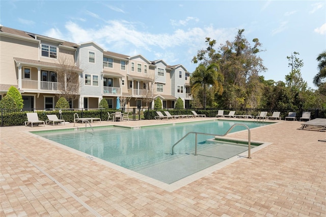 pool featuring a patio area, a residential view, and fence