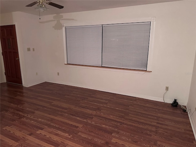 empty room with wood finished floors, a ceiling fan, and baseboards