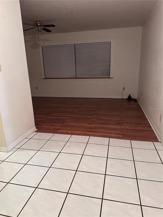 unfurnished room featuring ceiling fan, baseboards, and light tile patterned flooring