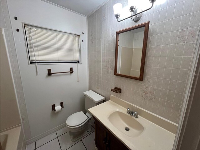 full bath with toilet, tile patterned flooring, a bathtub, vanity, and tile walls