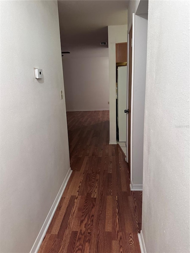 corridor with visible vents, baseboards, and wood finished floors