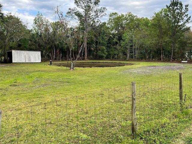 view of yard with an outbuilding and fence