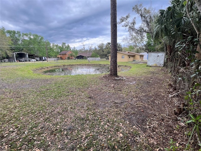 view of yard with a water view and a carport