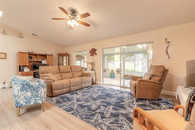 living room featuring visible vents, wood finished floors, baseboards, lofted ceiling, and ceiling fan