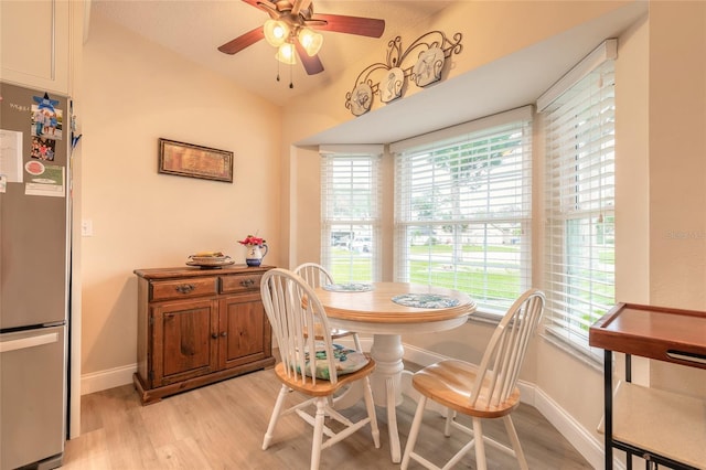 dining room with vaulted ceiling, light wood-style flooring, baseboards, and ceiling fan