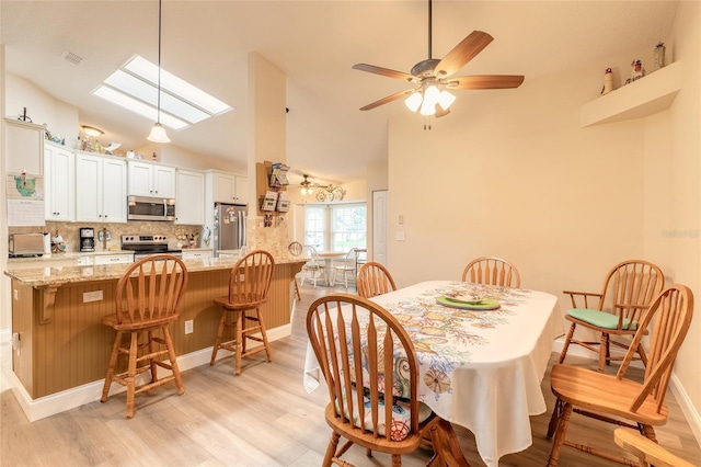 dining room featuring visible vents, a toaster, a skylight, light wood-style floors, and a ceiling fan