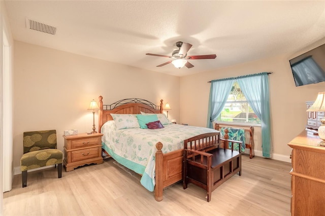 bedroom with baseboards, visible vents, light wood finished floors, and ceiling fan