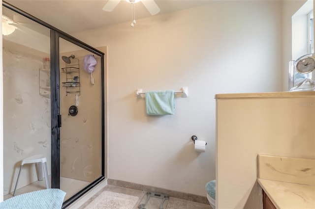 bathroom featuring baseboards, a stall shower, ceiling fan, tile patterned floors, and toilet