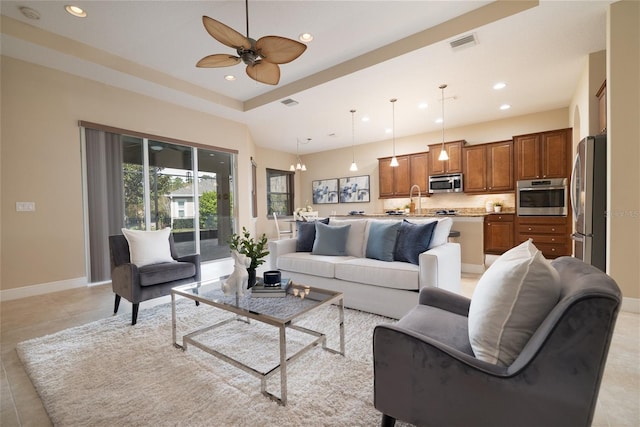 living area featuring baseboards, visible vents, a ceiling fan, and recessed lighting