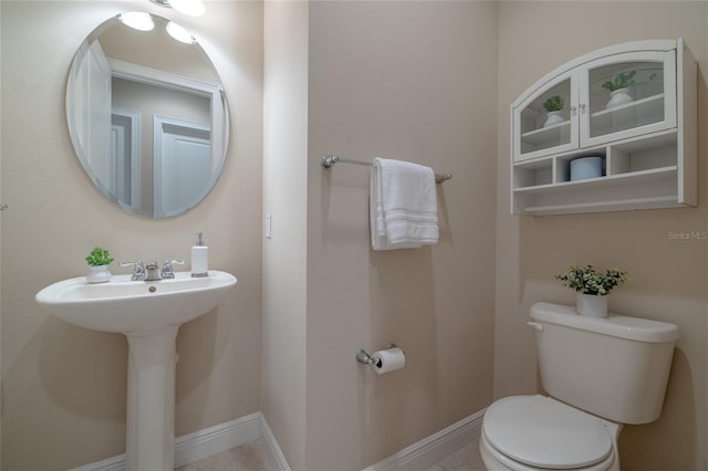 bathroom with toilet, baseboards, and a sink