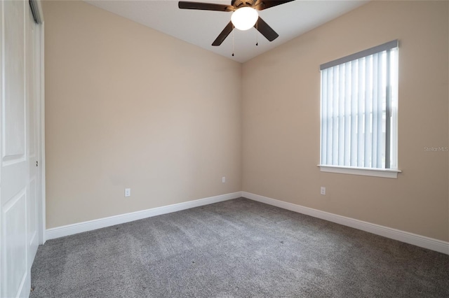 carpeted empty room featuring ceiling fan and baseboards