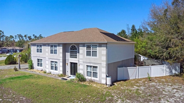 view of front of home with fence and a front lawn