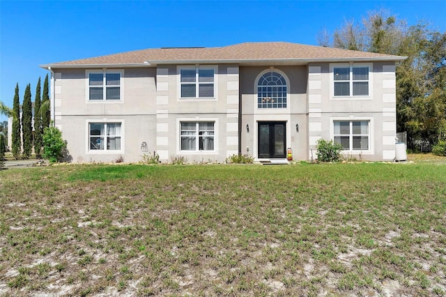 view of front facade featuring stucco siding and a front yard